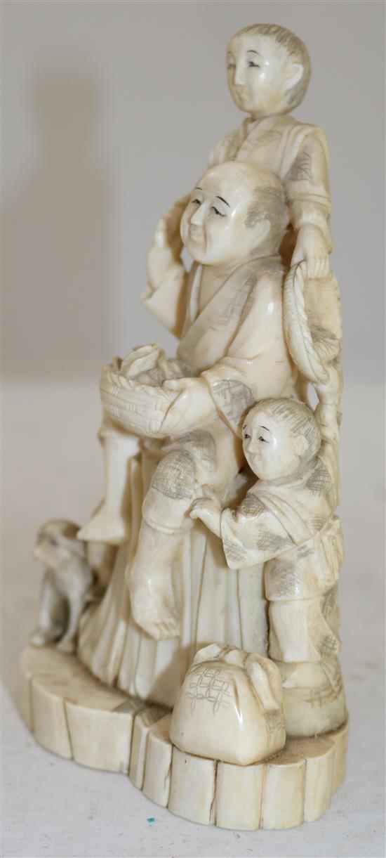 A Japanese walrus ivory okimono of a family, early 20th century, 16.8cm